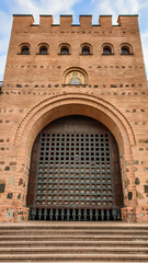 Golden Gate in Kiev seen from the front. The tower is symmetric.  Build of brick, and wood. Gate is lowered, no access to the tower. Stairway in front of the building.