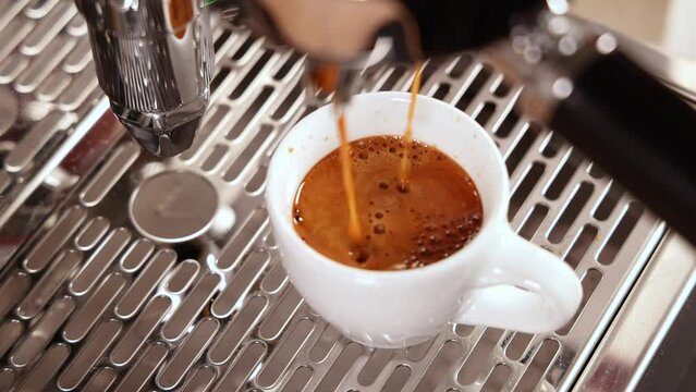 Espresso coffee dripping into a cup