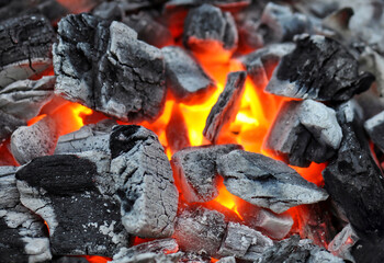 Lose-up of burning barbecue coals in bright red color