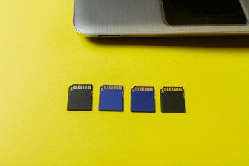 memory card and laptop on a yellow background.