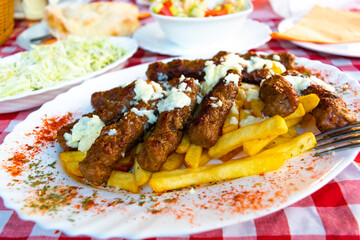 Bees fly near wooden hives taken out to a sunny meadow in the forest.