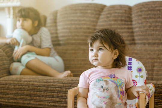 Closeup Shot Of A Little Girl Sitting And Watching TV With Her Older Sister