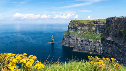 Beautiful scenery of the Atlantic Ocean and a cliff on a sunny day in Ireland