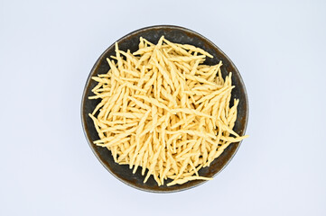 Top view of raw trofie pasta on a white background