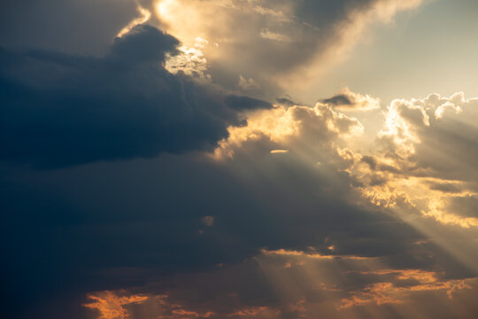 Mystical dramatic cloudy sky with sun behind the clouds and rays of light .Sky background. Photo in artistic style