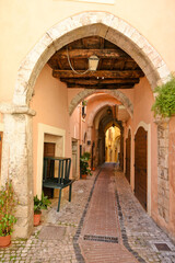 Fototapeta premium Vertical shot of a narrow cobblestone corridor path between old medieval buildings.