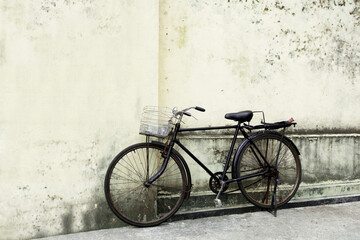 Fototapeta na wymiar Black vintage bicycle nearle wall on cobblestone street.