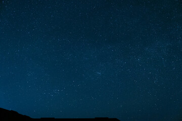 Beautiful night landscape. Stars in a clear sky without moon and clouds. Night scene over the roof...