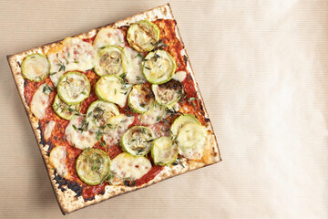 Matzah Pizza with tomato sauce, zucchini, parmesan cheese, thyme leaves for Jewish holiday Pesach on paper background.
