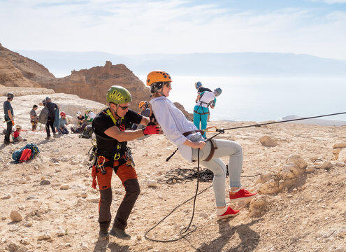 An experienced instructor explains to beginners how to use the equipment for snapping in the mountains of the Judean Desert near the Tamarim stream near Jerusalem in Israel