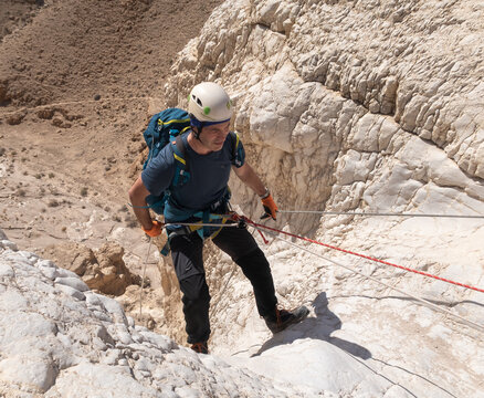 Athlete starts descent from the mountain with equipment for snapping in the mountains of the Judean Desert near the Tamarim stream near Jerusalem in Israel