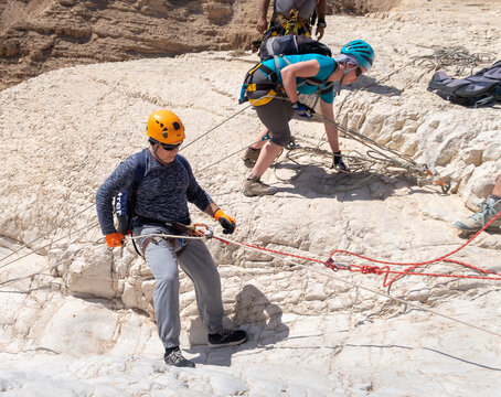 An experienced athlete starts the descent with the equipment for snapping in the mountains of the Judean Desert near the Tamarim stream near Jerusalem in Israel