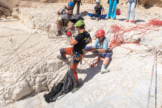 Experienced athletes check their snapping equipment before going down the mountain in the mountains of the Judean Desert near the Tamarim stream near Jerusalem in Israel