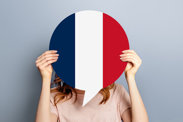 France elections vote concept. Student girl holds poster with france flag isolated over grey studio...