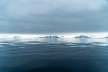 Panoramic view of Blue hour of the mountains, snow and Sea in Svalbard, Norway.