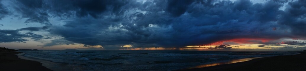 Fototapeta na wymiar beach sunset, colorful cloudy twilight sky reflecting on the sand gazing at the Indian Ocean