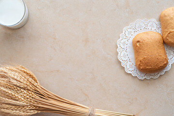 Wheat bread, bunch of wheat ears, fresh milk for Jewish holiday Shavuot on marble background with copy space.