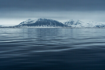 Panoramic view of Blue hour of the mountains, snow and Sea in Svalbard, Norway.