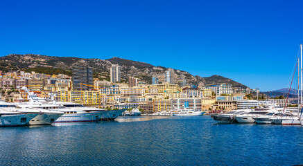 Monaco, Monaco - April 5 2022 - Big yachts in the port Hercule harbour with in the background the...
