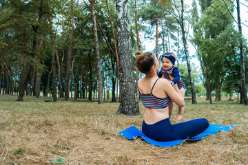 Mom and baby yoga outdoor classes. Wellness, family yoga class, practicing mindfulness and meditation, physical and mental health concept for moms.