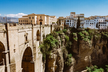 old anadalucia village with tall bridge and houses over rock formation on sunny day