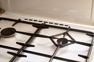 Fototapeta na wymiar a burning gas stove on a white kitchen stove