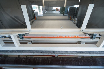 Machine that produces paper from recycled waste paper into large rolls. Manufacture of toilet paper and other paper products in factory.