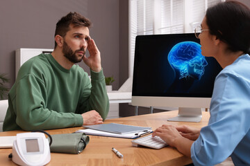 Neurologist consulting patient at table in clinic