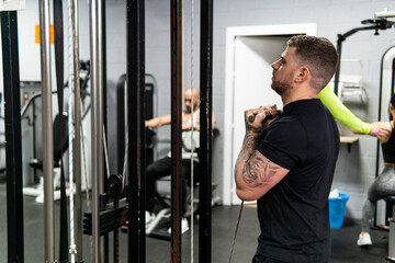 Fototapeta na wymiar Caucasian muscular man doing biceps exercises in the gym. Lifestyle, workout concept