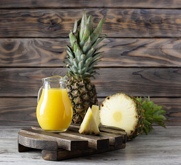 Fototapeta na wymiar Transparent jug with pineapple juice on a wooden stand
