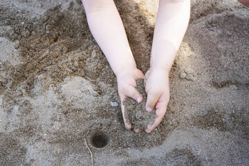 mains d'enfant dans le sable 