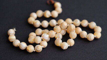 Mother of pearl nacre beads on black background.	