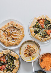 galette, flat lay, above, buffet catering, antipasto, mix, antipasti, pear tart, pine seeds, sauce, hummus, mediterranean, menu, tomatoes, mozzarella, french cuisine, open pie, slice, overhead, quiche