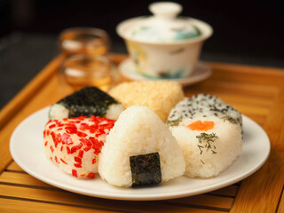 Tea set for the ceremony and Onigiri. Various shapes and fillings on a plate. Healthy snack. Japanese rice ball. Top view.