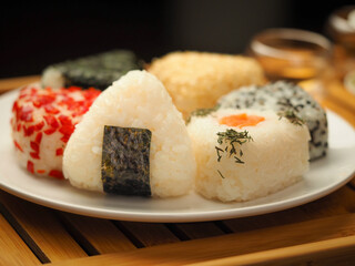 Onigiri of various shapes and fillings on a plate. Close-up food photo. Japanese rice ball.