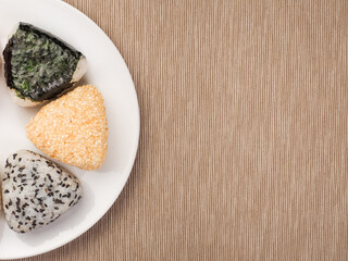 A series of shots of onigiri of various shapes and fillings on a plate. Top view. Japanese rice ball.