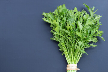 Mustard Green on dark background. Copy space