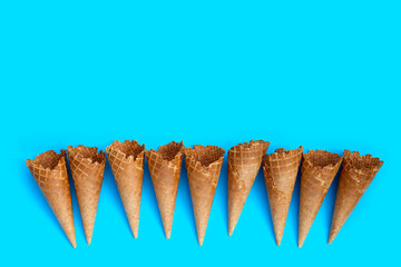 Empty ice cream cone on blue background.