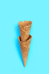 Empty ice cream cone on blue background.
