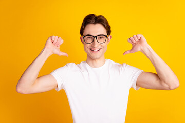 Photo of young handsome man indicate thumds himself proud branding cool isolated over yellow color...