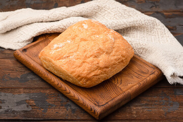 Bread, baguette, boton, rye on a wooden background.