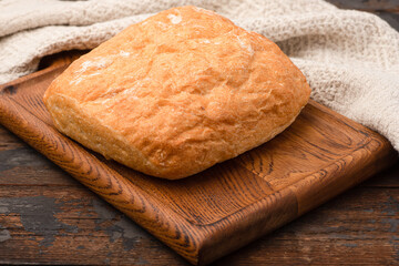 Bread, baguette, boton, rye on a wooden background.