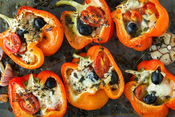 baking sheet with bell peppers stuffed with feta and olives on the table