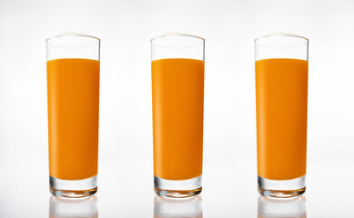 A glass of fresh carrot juice on white background