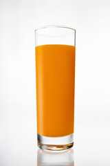 A glass of fresh carrot juice on white background
