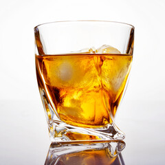 Glass of scotch whiskey with ice on a white background, close-up