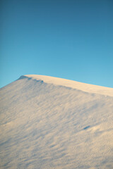 Snowy slope. Mountain in winter. Top of snowy mountain against sky. Beauty of nature.