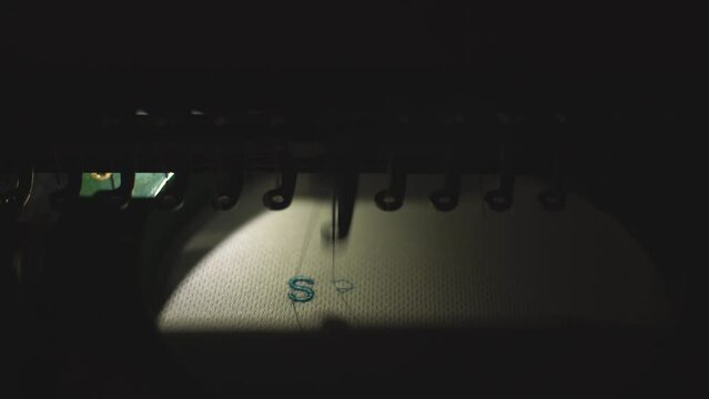 sewing machine embroiders blue inscription