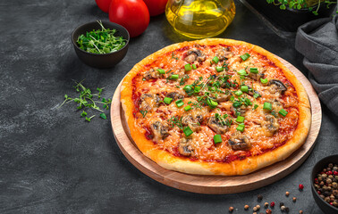 Homemade pizza with mushrooms, cheese, tomatoes and fresh herbs on a dark background. Fast food.