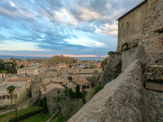 Panoramic view of the old famous city of Bolsena and Lake Bolsena at sunset. Province of Viterbo, Italy, Lazio. Cityscape and tiled roofs